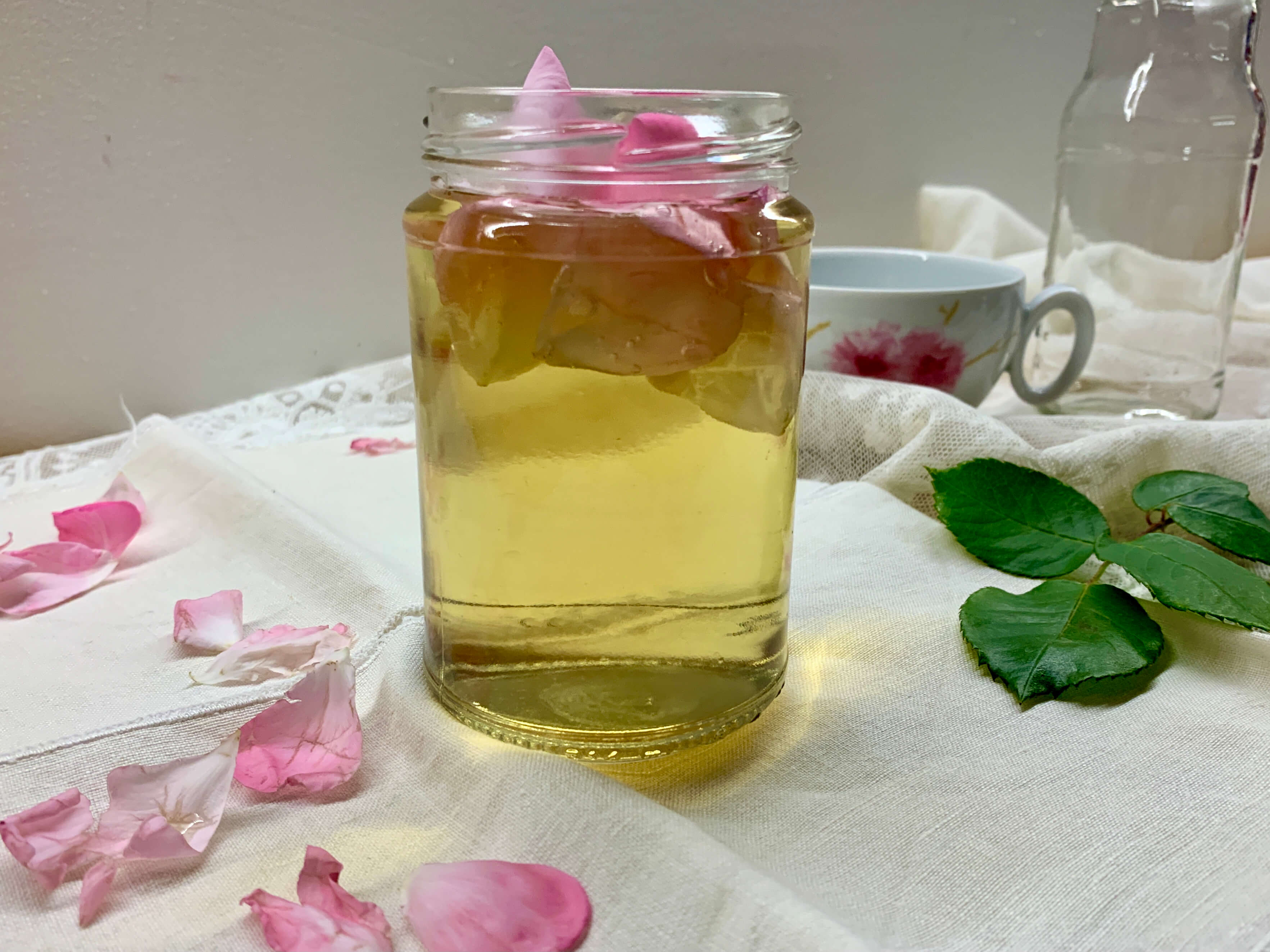 Barattolo con acqua di rose e petali di rosa