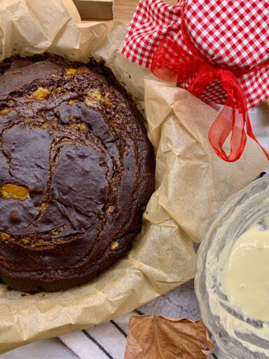 torta al cioccolato vicino a un vasetto di marmellata e a una ciotola con lievito naturale